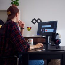 man in baseball cap sat at desk