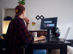 man in baseball cap sat at desk