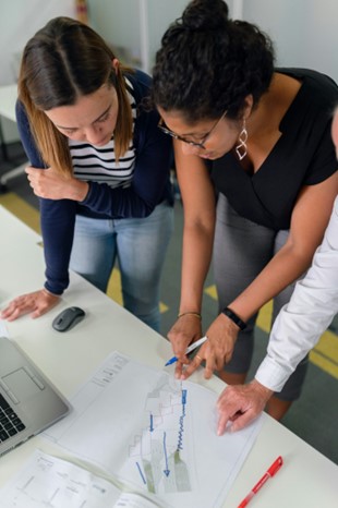 two women studying charts on a desk