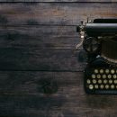 vintage typewriter to side of image on top of a wooden surface