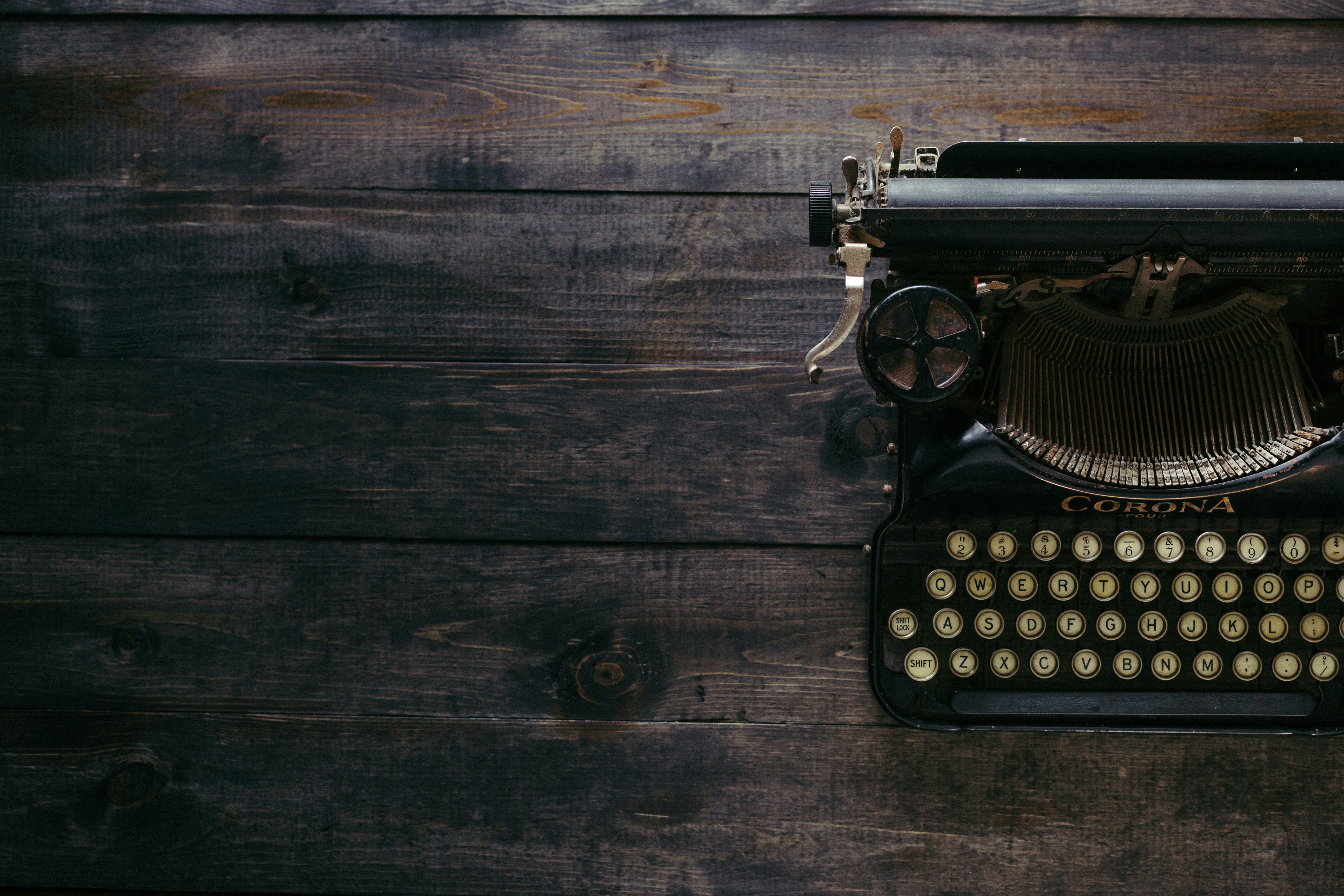 vintage typewriter to side of image on top of a wooden surface