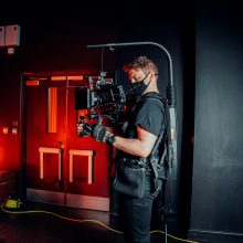 cameraman standing in front of a door