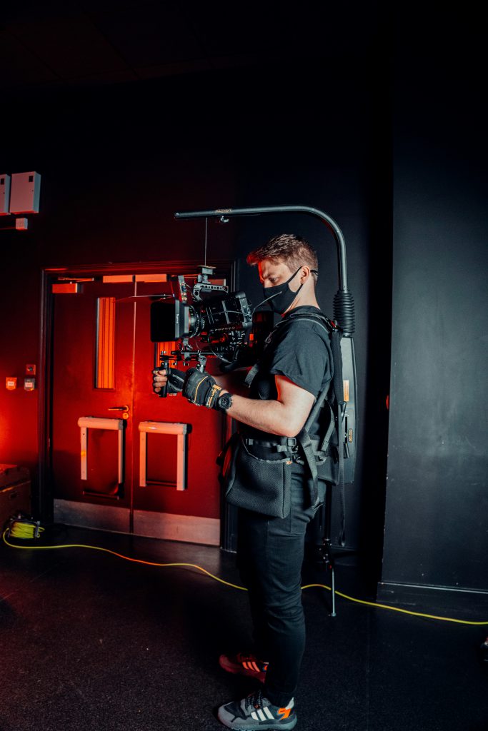 cameraman standing in front of a door 